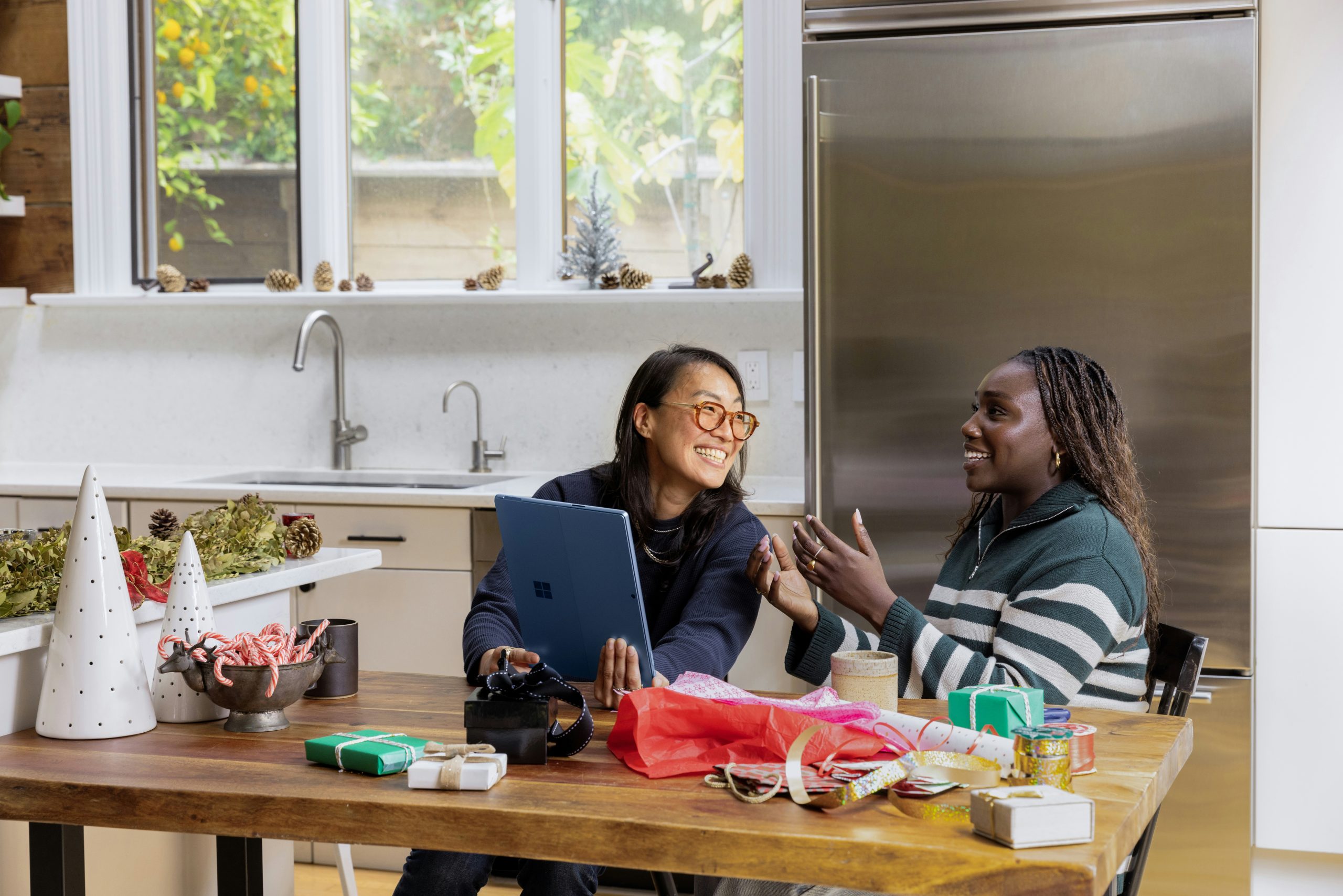 two women smiling in a kitchen while working together