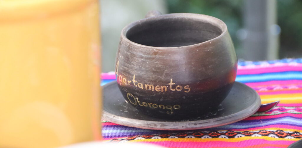 A cup with "Apartmentos Otorongo" written on it