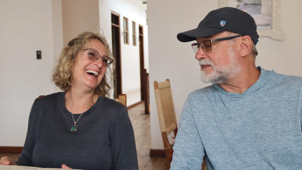 a woman and man smiling and talking