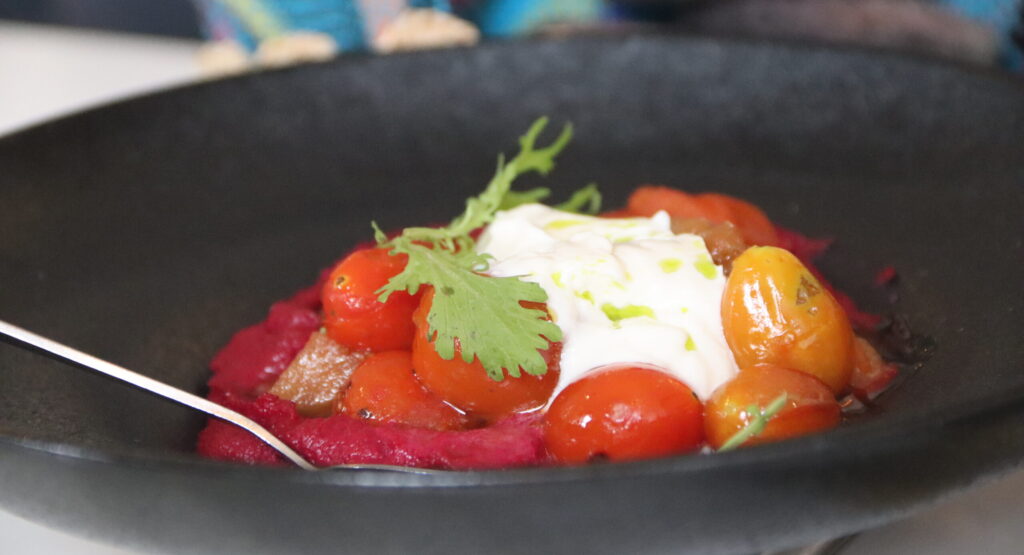 a plate of hummus and tomatoes