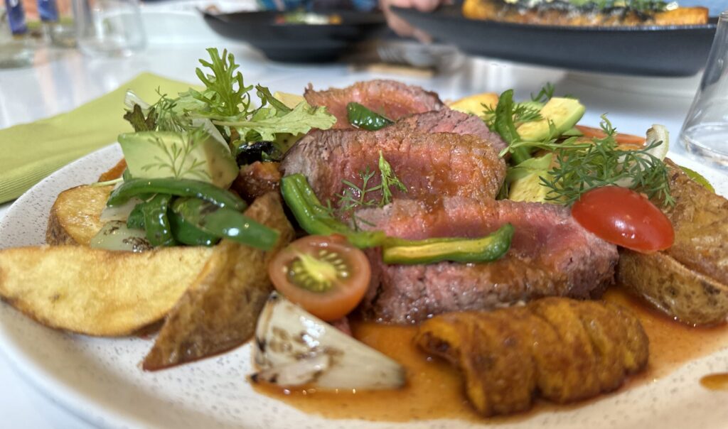 A plate of rib eye steak and potatoes