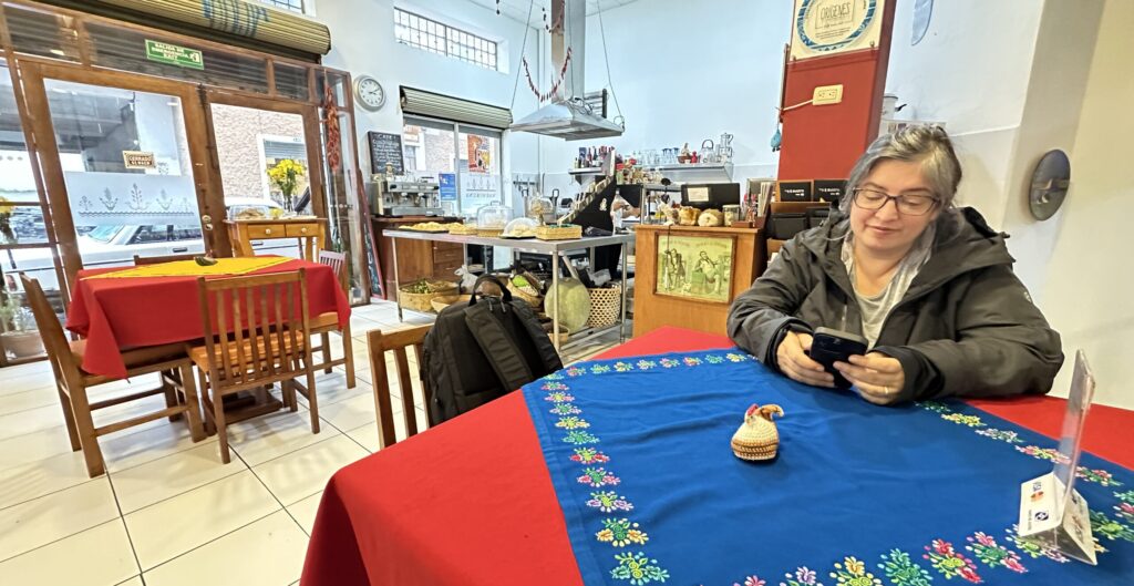 A woman at a table in a restaurant looking at her phone