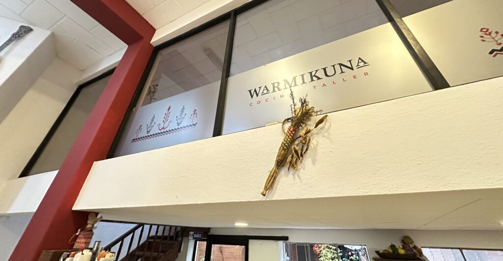 a sign for Warmikuna Cocina Taller