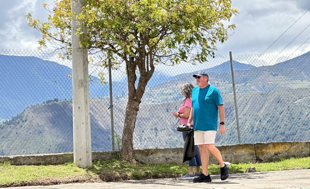 Two people walking in front of a tree