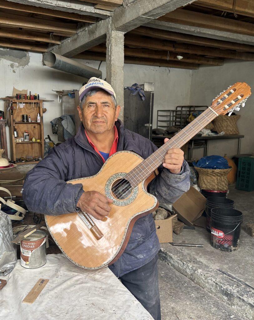 Mr. Uyaguari holding a guitar being made