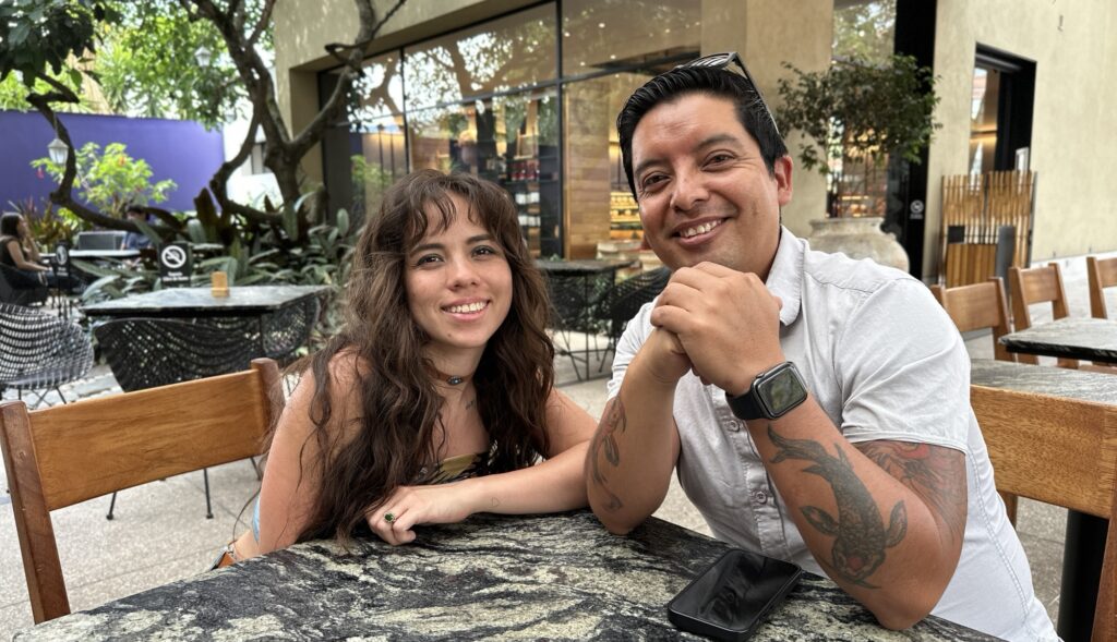 A woman and man sitting at a table and smiling for the camera