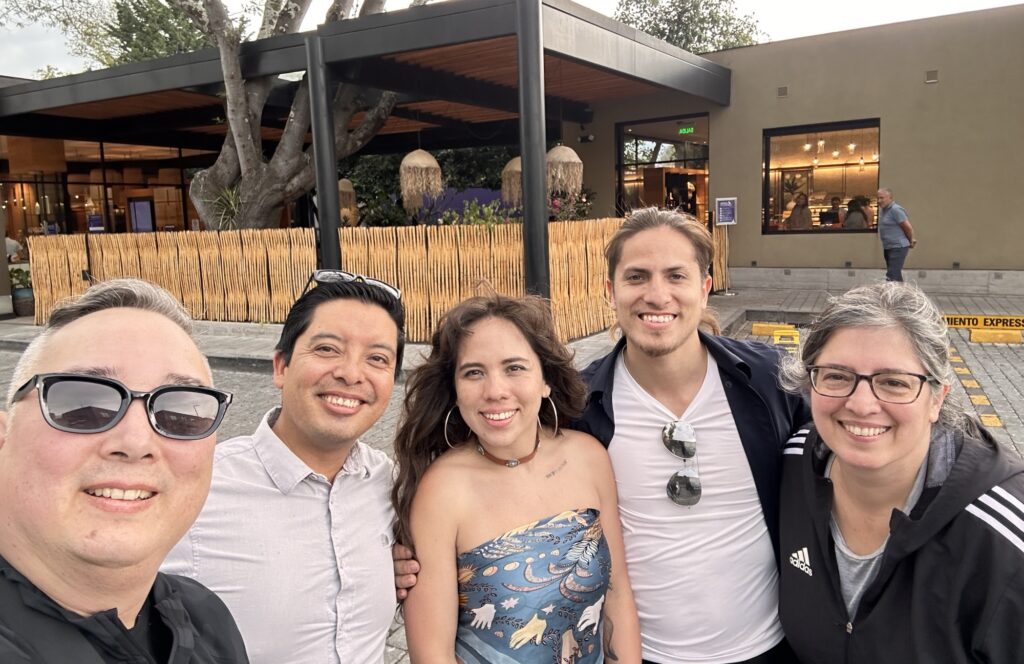 A group of friends smiling in front of a cafe