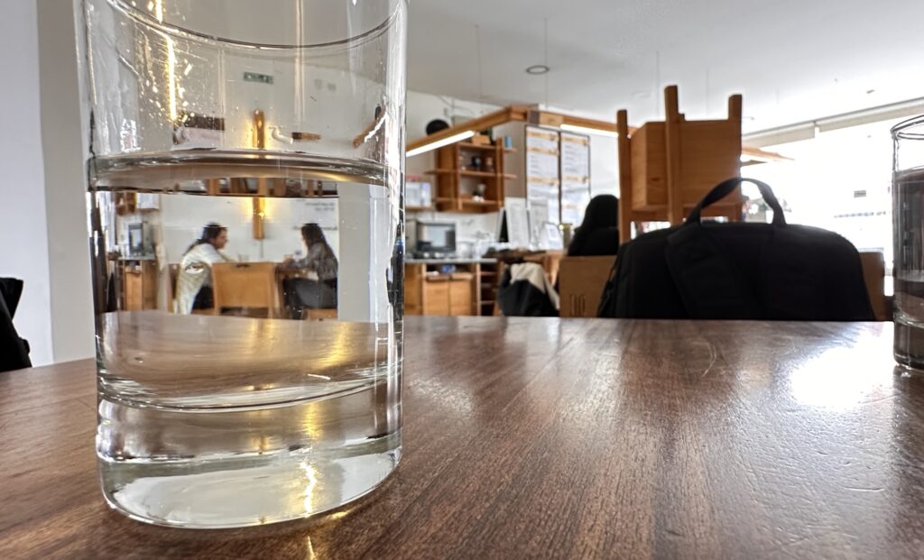 a view of a cafe with a glass of water on a table