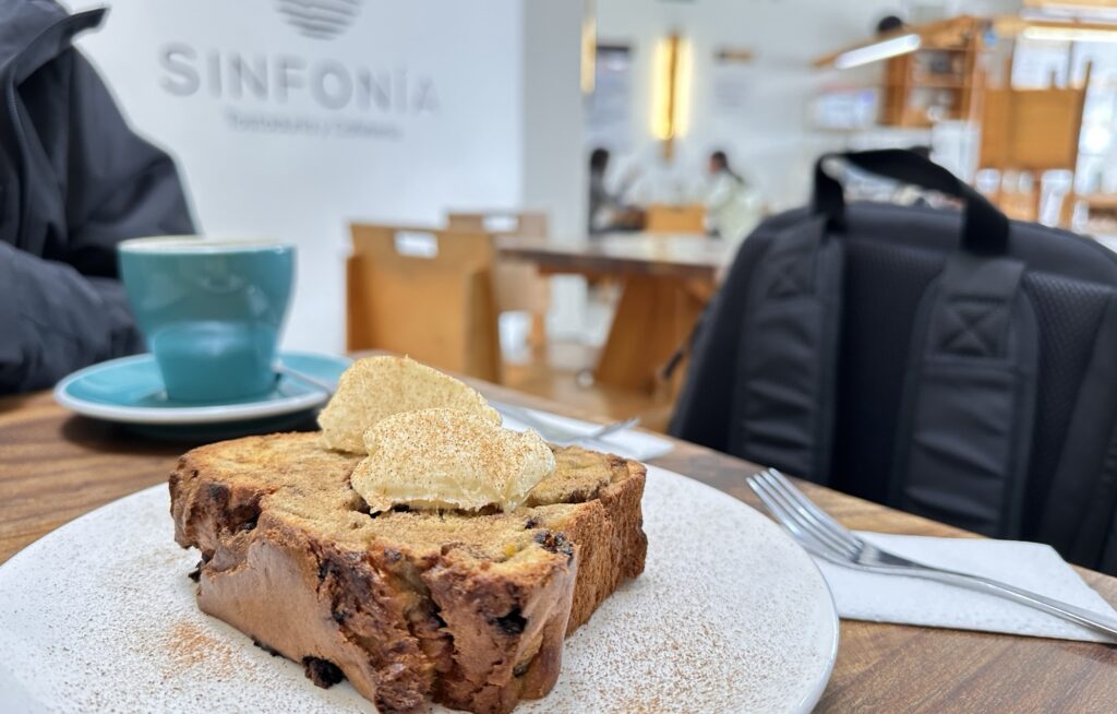 Banana bread at Sinfonia cafe on a table next to a backpack