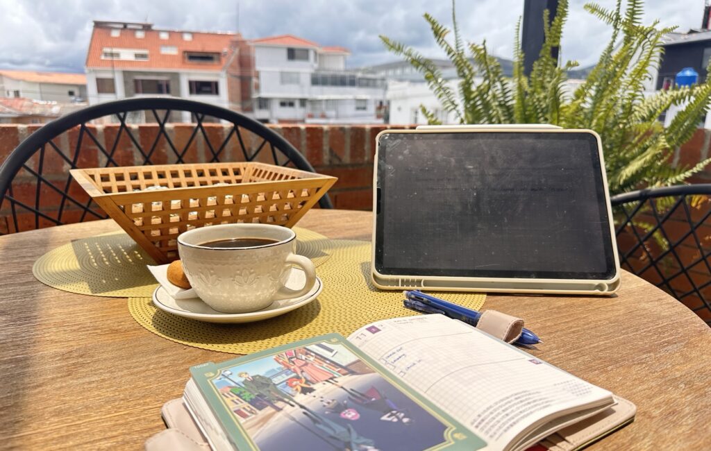 iPad, notebook and coffee on a table on a veranda