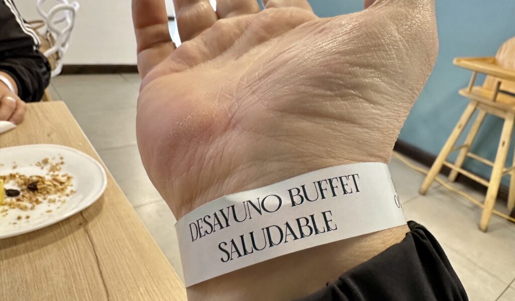 A wrist band saying desayuno buffet saludable