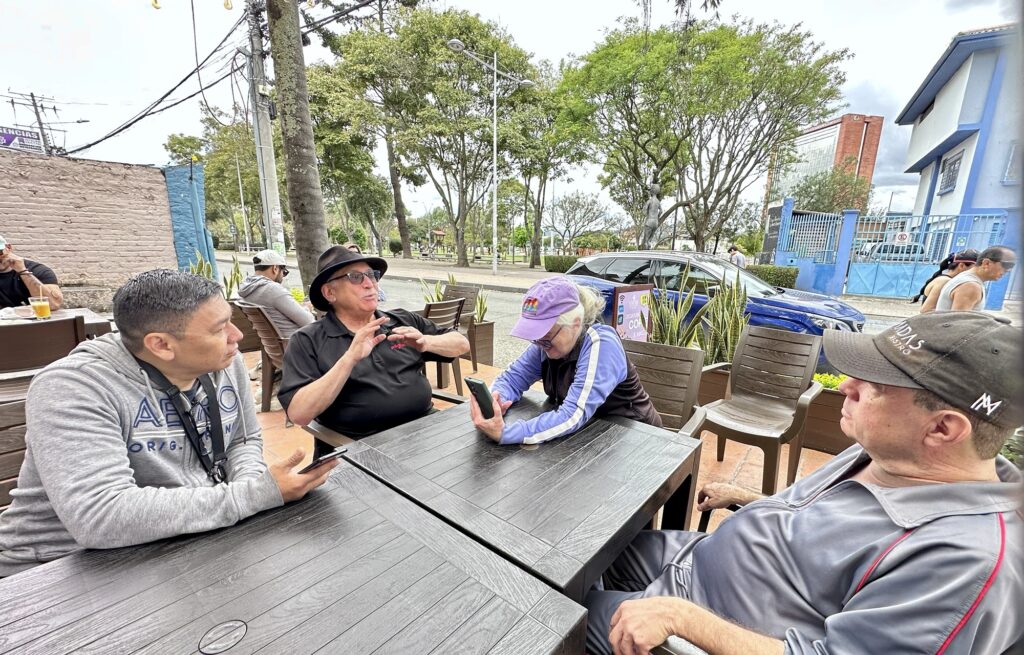 four people sitting outside at a table
