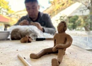 a ceramic figurine in front of a man