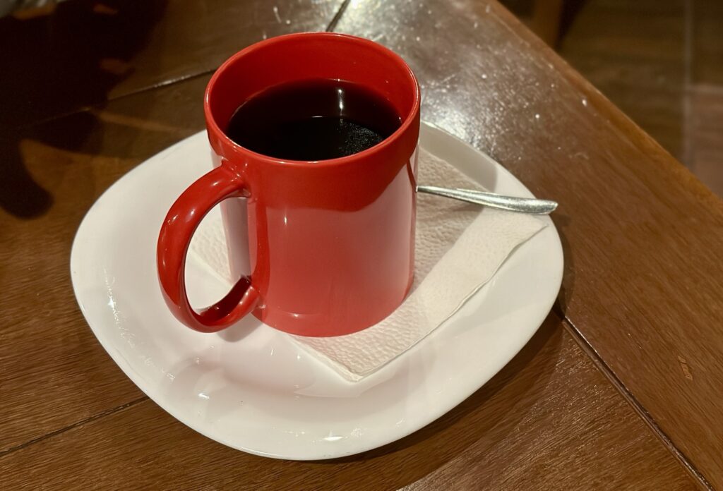 a red mug with dark liquid