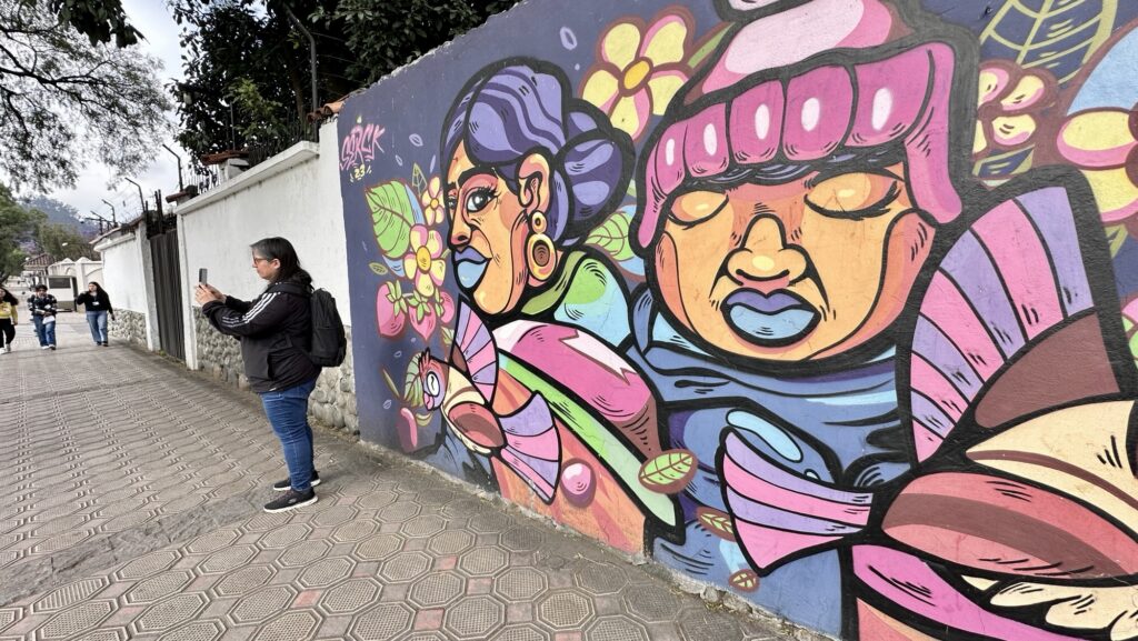 woman next to a mural