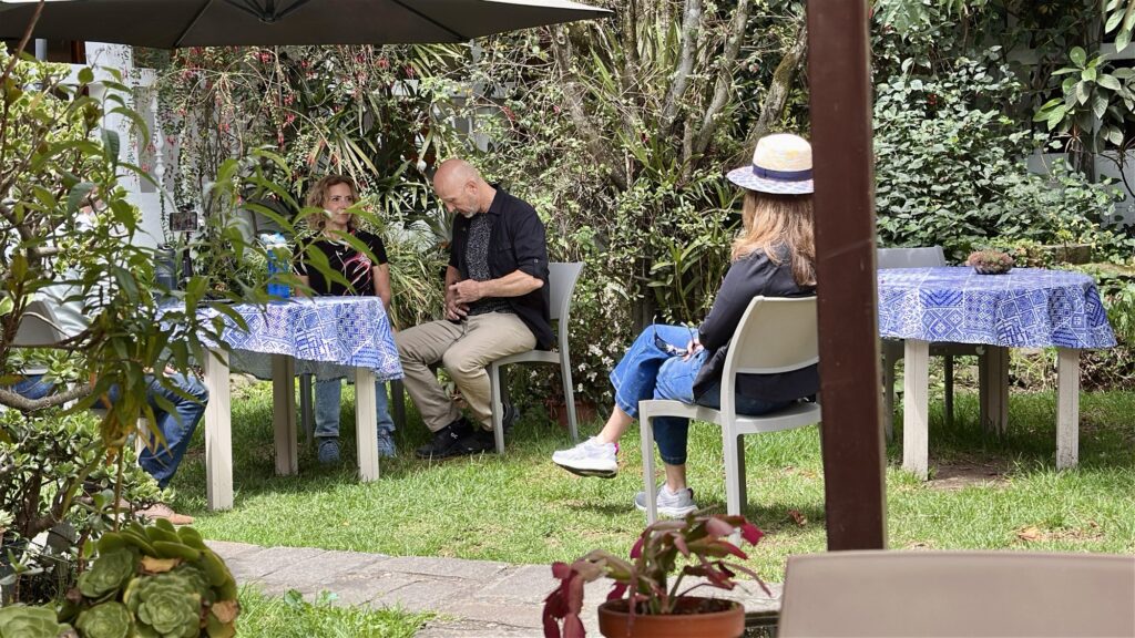 People sitting in chairs in a garden courtyard