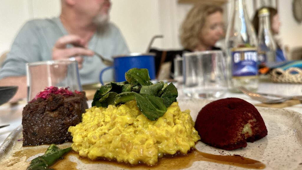 pulled pork, a corn dish and an avocado with light kim chee dust
