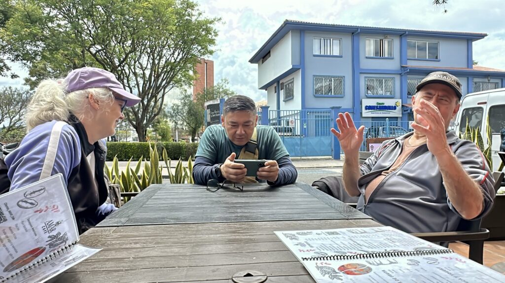 three people sitting at a table outdoors