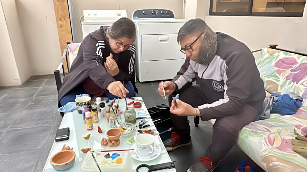 a man and woman painting ceramics