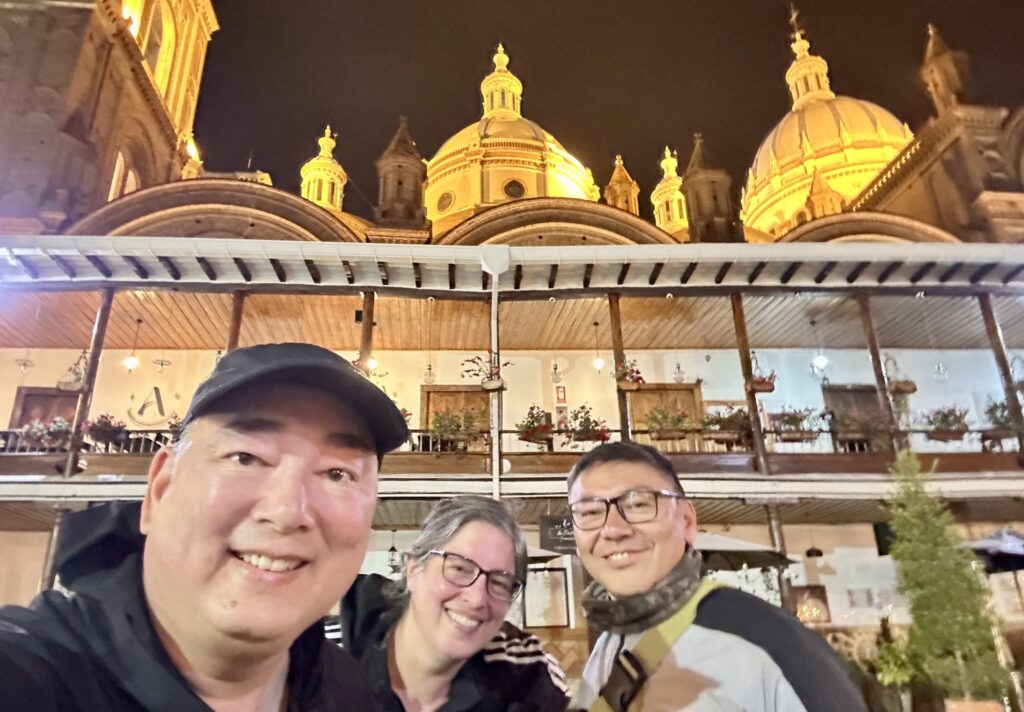 three people taking a selfie in front of the Cuenca cathedral