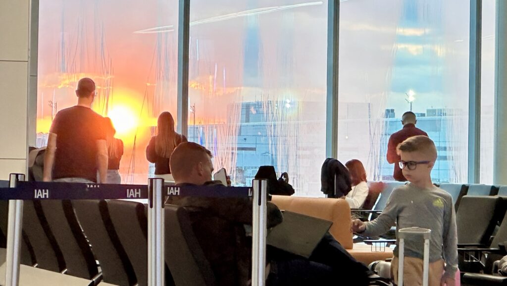 people taking pictures of a sunrise at the airport