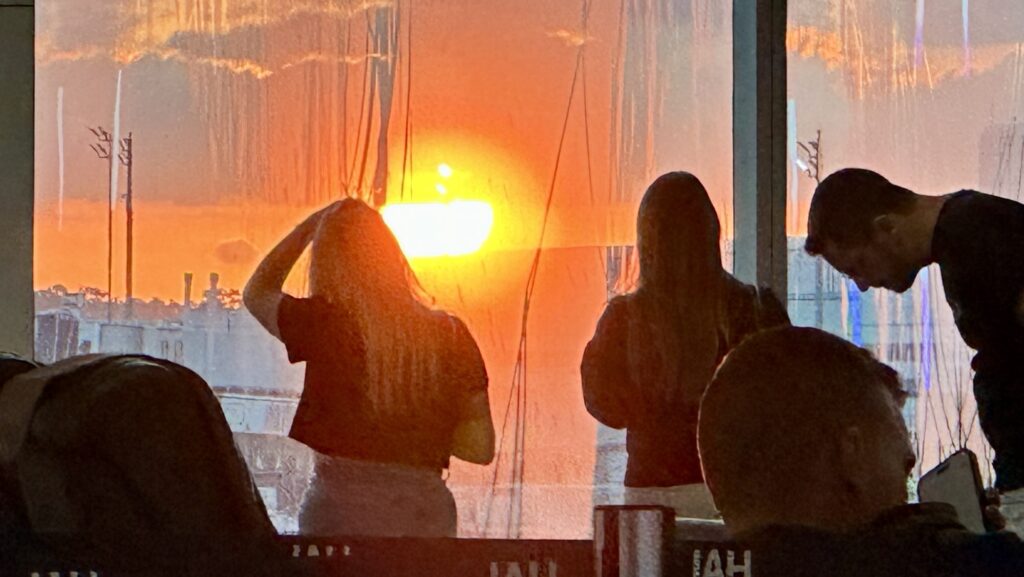 people watching a sun rise through a window