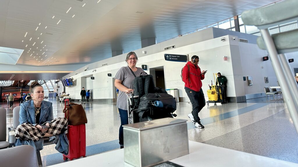 a woman pushing a luggage cart