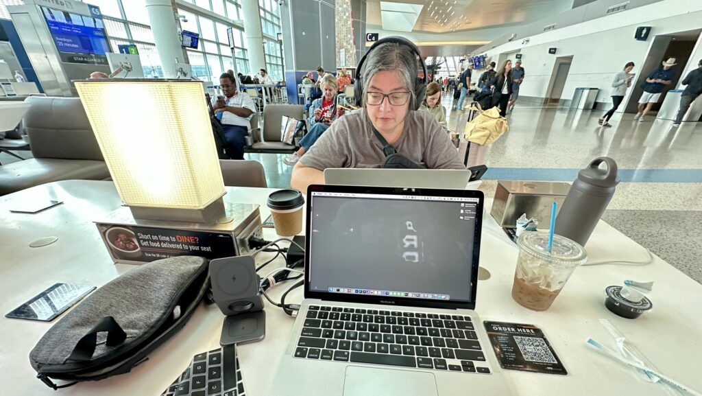 a woman working on a laptop at the airport