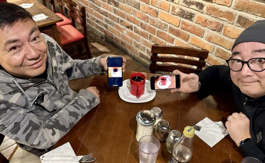 two men showing pictures on their phones