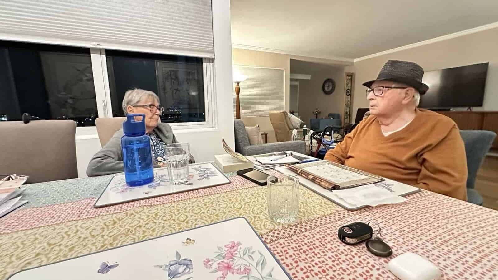 an elderly couple sitting at a table